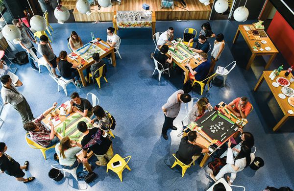 A mahjong parlor in Chengdu with four ongoing games teaching foreigners how to play.