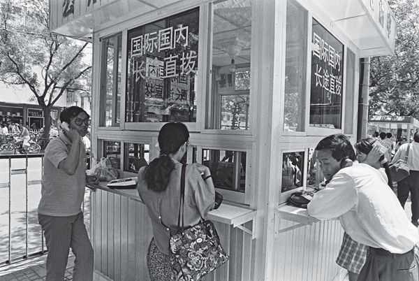 Chinese residents making long distance phone calls from a phone booth.