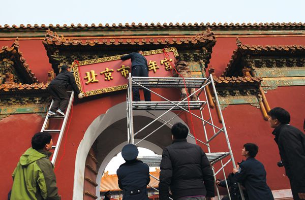 Workers remove the sign of the Beijing Youth Palace from Shouhuang Hall imperial temple in Jingshan Park in 2013, after 57 years' occupation